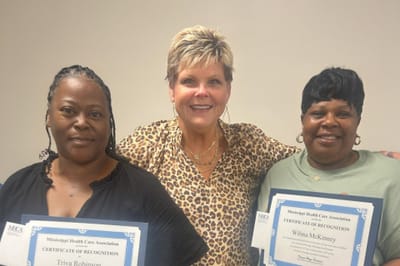 Staff members celebrating recognition awards with certificates
