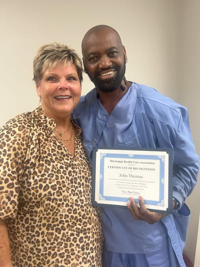 Staff member celebrating a recognition award with a resident