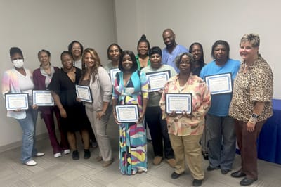 Group photo of staff with completion certificates