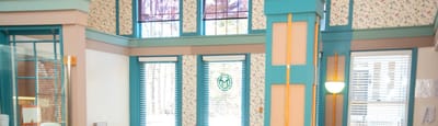 Bright common area with floral wallpaper and large windows