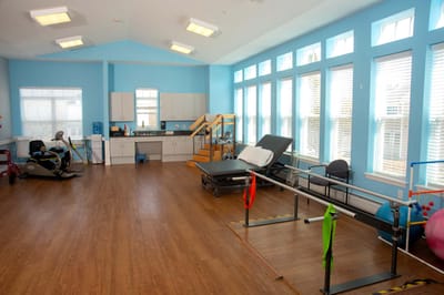 Bright interior of a therapy room with equipment and windows