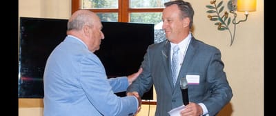Two men shaking hands during a ceremony