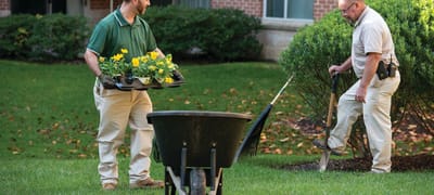 Two staff members gardening in an outdoor area