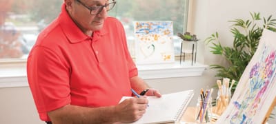 Senior man painting in a bright indoor space