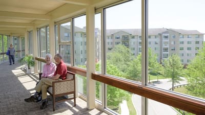 Residents enjoying conversation in a sunny hallway
