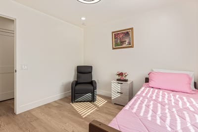 Cozy private resident room with a bed and chair