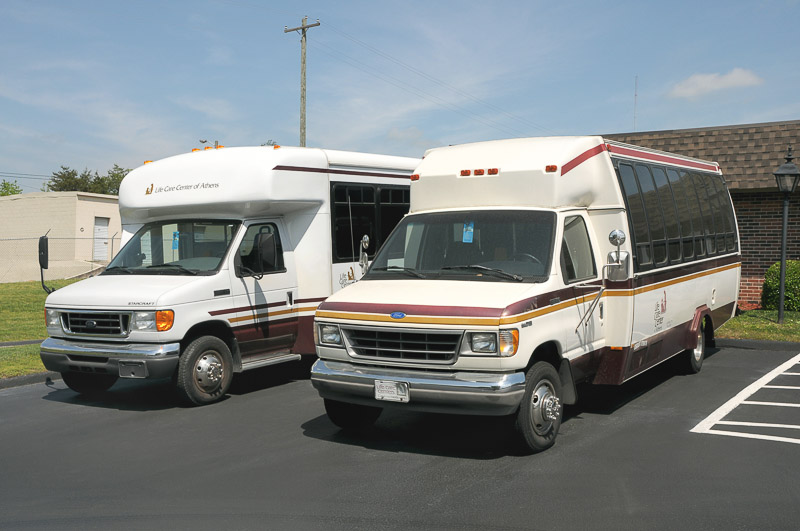 Two facility transport vehicles parked outside