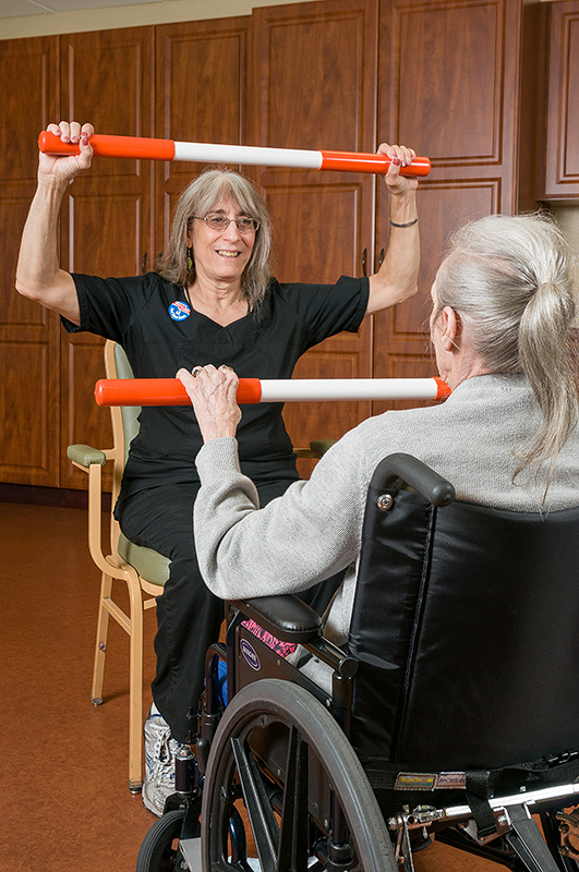 Staff assisting a resident with therapy exercises