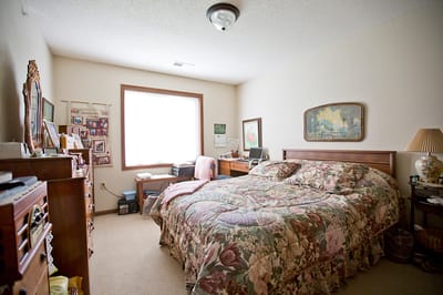 A cozy private resident room with floral bedding