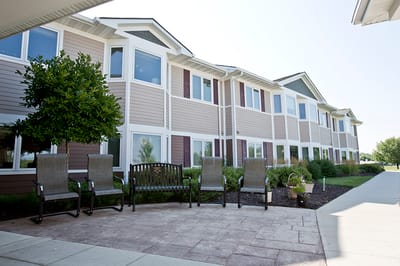 Exterior view of a senior living facility with seating area