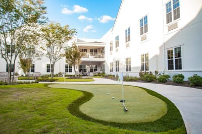 Outdoor putting green with lawn space and building