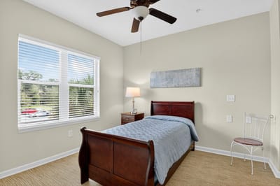 An interior shot of a private room with a bed and window