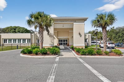 Exterior view of the community center with palm trees