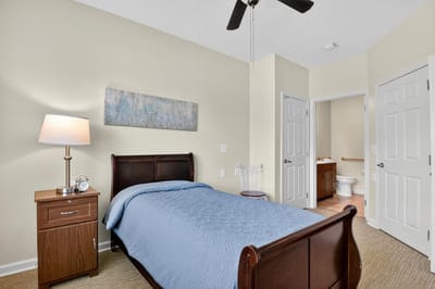 Private resident room with bed and bedside lamp