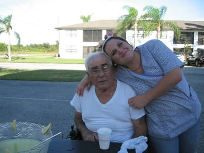 A resident with a staff member outdoors at the facility
