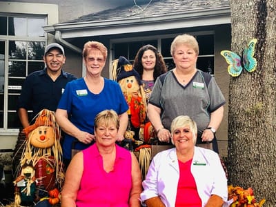 Staff members with seasonal decorations outside