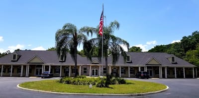 Exterior view of the facility with palm trees and flag