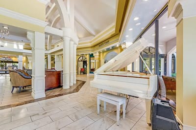 Bright common area with a grand piano and seating