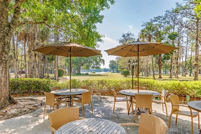 Outdoor seating area with umbrellas overlooking a landscaped view