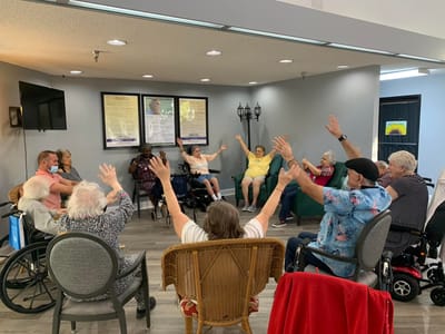 Residents engaging in a group activity with raised arms