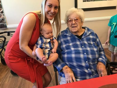 Staff member holding a baby with a resident