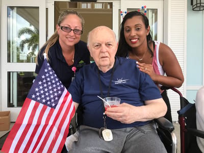 Residents celebrating with staff and a small American flag