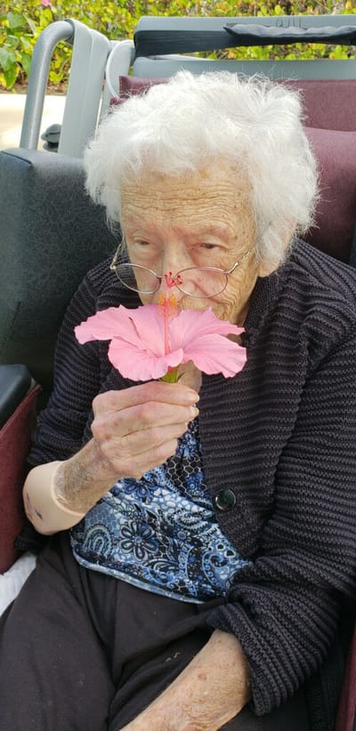 Resident enjoying a flower outdoors