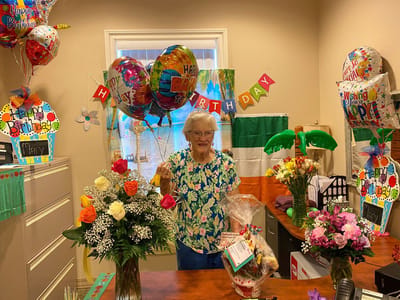 Resident celebrating birthday with balloons and flowers