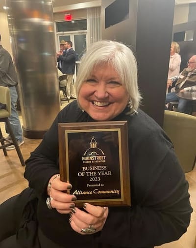 Resident celebrating award with plaque