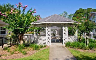 Outdoor gazebo surrounded by flowering plants