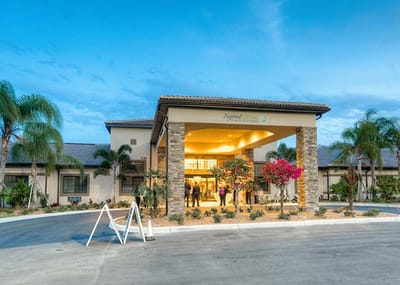 Exterior view of Inspired Living at Sun City Center with palm trees
