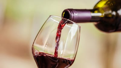 A glass of red wine being poured