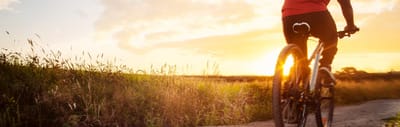 A person biking at sunset in an outdoor setting