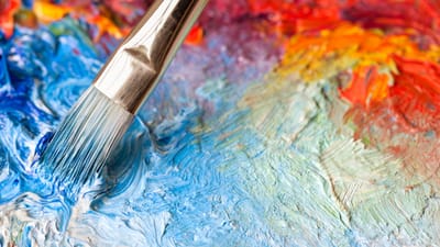 Close-up of a paintbrush on colorful paint texture