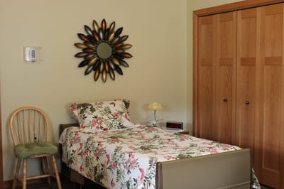 Cozy resident room with floral bedding and wooden furniture