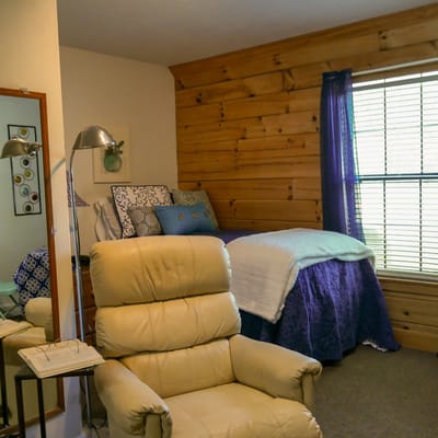Cozy resident room with a bed and armchair