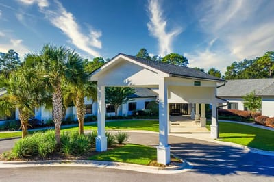 Entrance of a senior living facility with landscaped surroundings