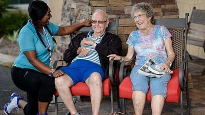 Residents enjoying a sunny day outdoors with staff