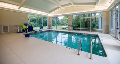 Indoor swimming pool with large windows and seating