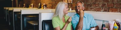 Osprey Village, nursing home in Fernandina Beach, FL — Couple sharing ice cream in a cozy diner setting
