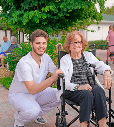 Staff member posing with a resident outdoors
