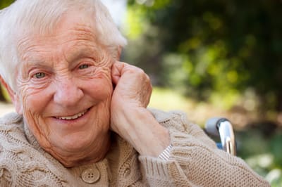 Smiling elderly woman in a garden setting