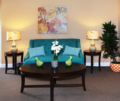 Cozy common area with a teal sofa and decorative lamps