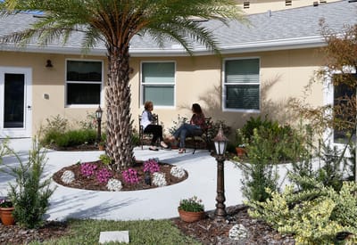 Two women conversing in a peaceful outdoor garden area