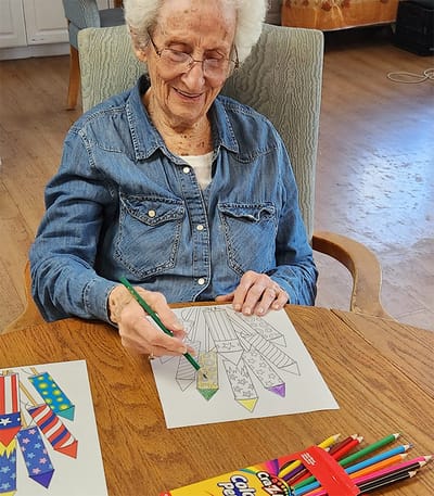 Senior resident coloring at a table
