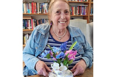 Resident holding a flower arrangement in a common area