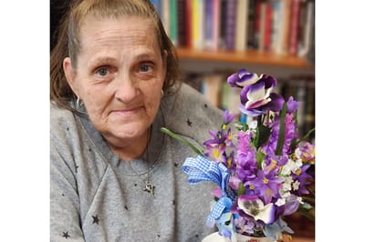 Resident holding a bouquet of purple flowers