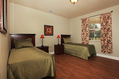 A cozy, well-furnished resident room with two beds