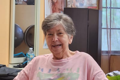Resident in a common area smiling at the camera