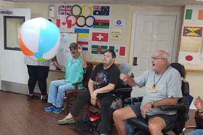 Residents playing with a beach ball in an activity room